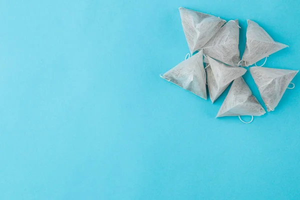 Tea bag pyramid on a gentle blue background. to make tea. place for text. top view