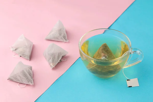 Teebeutel Pyramide Und Tasse Mit Tee Auf Sanftem Blauen Und — Stockfoto