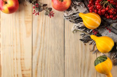 Sonbahar. doğal bir ahşap arka plan üzerinde sıcak ekose, sarı leavesmin, dekoratif kabak ve elma ile sonbahar kompozisyon. üst görünüm