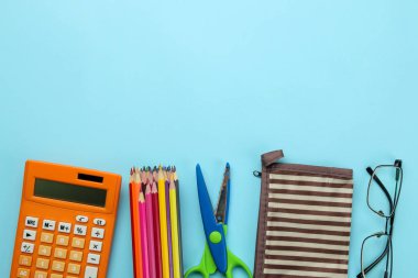 Okula geri dön. kırtasiye renkli kalemler, makas ve parlak mavi arka plan üzerinde kalem durumda. üst görünüm