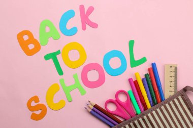 Okula geri dön. kırtasiye, okul malzemeleri, metin ve kalem kutusu parlak pembe arka plan üzerinde kalemler ile. üst görünüm.