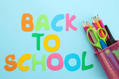 Okula geri dön. kırtasiye renkli kalemler, parlak mavi bir arka plan üzerinde bir cam makas. üst görünüm