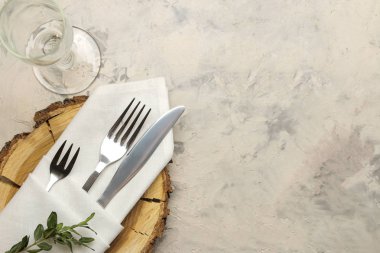 tablo ayarı. Çatal. cam, çatal, beyaz peçete bıçak ve hafif beton bir masa üzerinde ahşap bir stand. üst görünüm