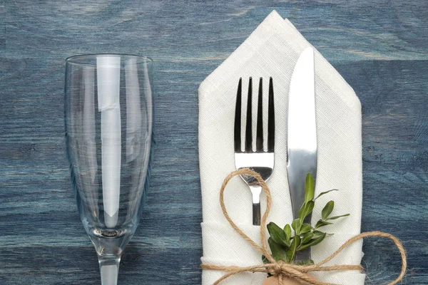 表设置 酒杯叉 刀在蓝色木桌上的白色餐巾纸 顶部视图 — 图库照片