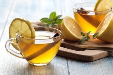 Kahverengi ahşap bir masada cam bardak zencefil ve nane ile limon ve tarçın sopa ile Çay. Isınma bir içecek. Sonbahar veya kış içeceği.