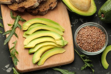 Avokado, ekmek. avokado sandviç yapmak için malzemeler. Karanlık bir arka planda. yukarıdan görünüm.