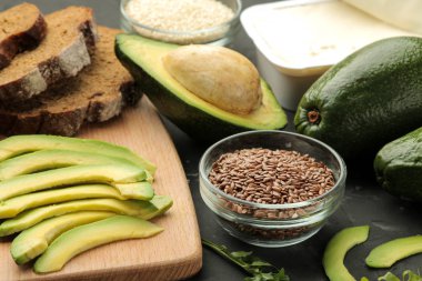 Avokado, peynir, ekmek. avokado sandviç yapmak için malzemeler. Karanlık bir arka plan üzerinde.