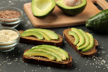 Avokado, ekmek. avokado sandviç yapmak için malzemeler. Karanlık bir arka plan üzerinde. 