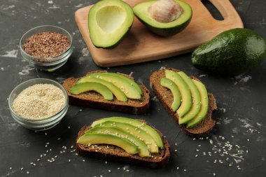 Avokado, ekmek. avokado sandviç yapmak için malzemeler. Karanlık bir arka plan üzerinde. 