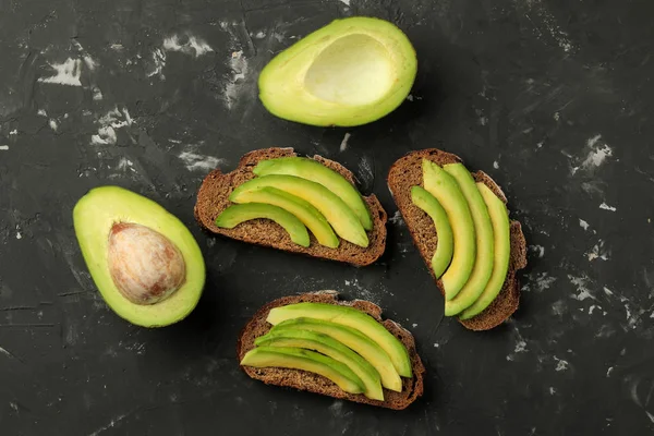 Sándwich Pan Rodajas Aguacate Sobre Fondo Hormigón Negro Haciendo Sándwiches —  Fotos de Stock