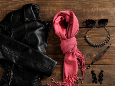 Giysi ve aksesuarlar. Kahverengi ahşap arka plan üzerinde siyah tarzda kadın giyim ve aksesuarları. Düz yatıyordu. Üstte görüntü