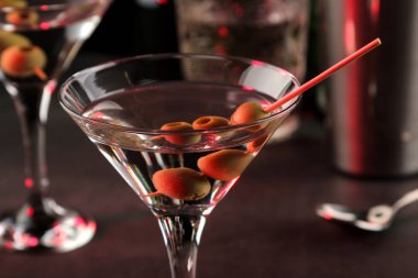 Martini. Bar tezgahındaki barda koyu bir arka plan üzerinde bir bardak zeytin ile alkollü içecek martini. bar envanteri. Kokteyl