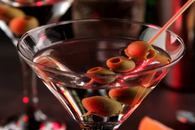 Martini. Bar tezgahındaki barda koyu bir arka plan üzerinde bir bardak zeytin ile alkollü içecek martini. bar envanteri. Kokteyl