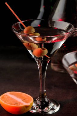 Martini. Bar tezgahındaki barda koyu bir arka plan üzerinde bir bardak zeytin ile alkollü içecek martini. bar envanteri. Kokteyl