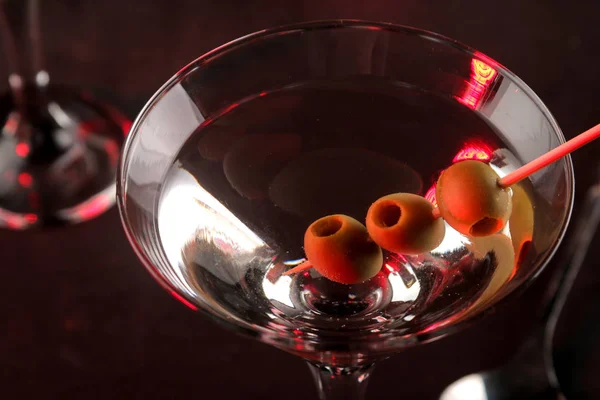 Martini. Alcoholic drink martini with olives in a glass on a dark background in the bar on the bar counter. bar inventory. cocktails