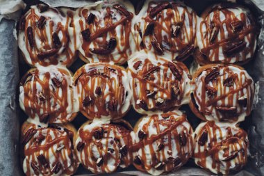 Geleneksel tarçınlı çörek pekan fındık ve kağıt, en iyi görünümü pişirme içinde karamel sos ile