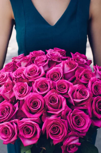 Woman with huge bouquet of pink roses