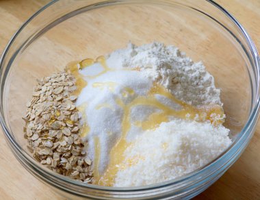 Yulaf gevreği, un, Hindistan cevizi pul, şeker ve bal bir cam kase.