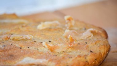 Kimyon tohumu ve domuz pastırması parçaları ile düz ekmek