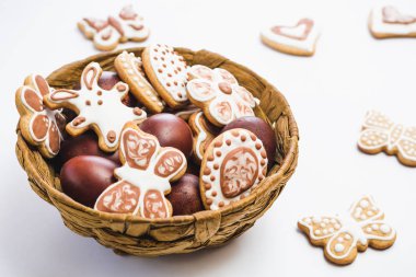 Gingerbread, çikolata ve Beyaz pudra şekeri ve tavuk yumurta beyaz bir yüzey üzerinde kahverengi bir sepet içinde kaplı
