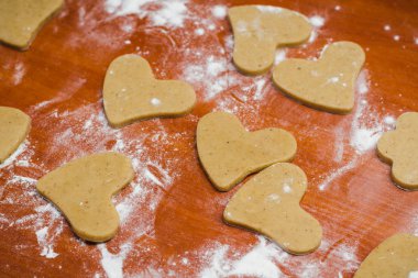 Buğday unu ile dökülür ahşap bir masa üzerinde bir kalp şeklinde kesilmiş gingerbread