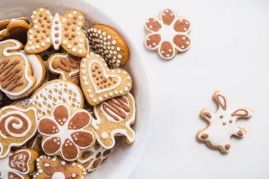 Gingerbread çerezleri Paskalya bunny, kalp, kelebek ve çiçek, şeklinde kaplı beyaz ve Çikolata buzlanma şeker, beyaz bir yüzey üzerinde beyaz bir tabak ile