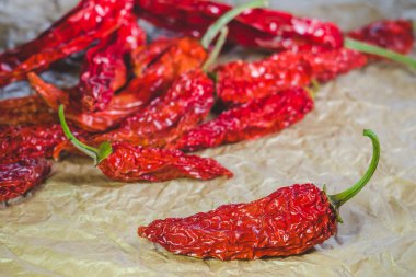 Sıcak bir kırmızı biber kırmızı biber bir arka plan üzerinde kuru; İşçiliği kağıt üzerinde closeup bulunduğu