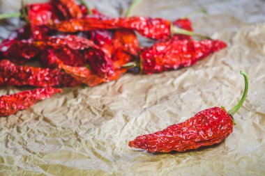 Sıcak bir kırmızı biber kırmızı biber bir arka plan üzerinde kuru; Kağıt işçiliği üzerinde bulunduğu