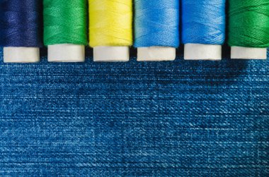 Yeşil, sarı ve mavi konu satırındaki denim düzenlenmiş makaralar