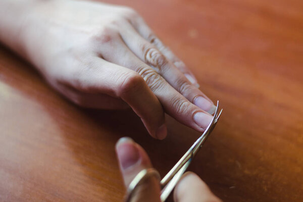 The process of nail clippingl scissors. Hand care concept. Soft focus.