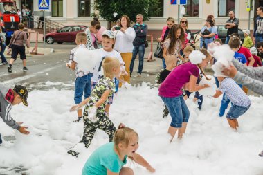 Horki, Belarus - 25 Temmuz 2018: Çocuk kişilik bir kalabalık öğleden sonra parkta bir partide beyaz köpük ile farklı yaş oyun