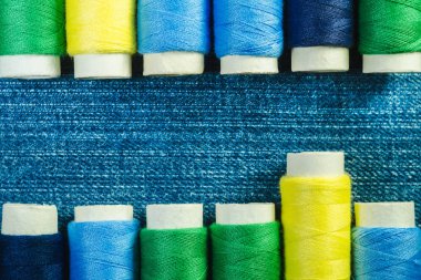 Mavi, sarı ve yeşil dikiş ipliği denim iki satırda kopya alanı ile düzenlenen makaralar