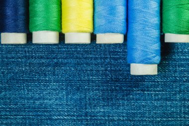 Mavi, sarı ve yeşil dikiş ipliği denim satırındaki kopya alanı ile düzenlenmiş makaralar