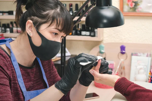 Manikiurzystka Czarne Rękawiczki Lateksowe Tworzą Kształt Paznokci Klienta Salonie Kosmetycznym — Zdjęcie stockowe