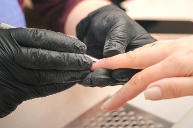 Güzellik Salonu bir istemciye bir manikür bir manikürcü Siyah lateks eldiven yapar, yakın çekim.