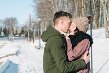 Parkta kış güneşli bir günde sarılma aşık genç Çift