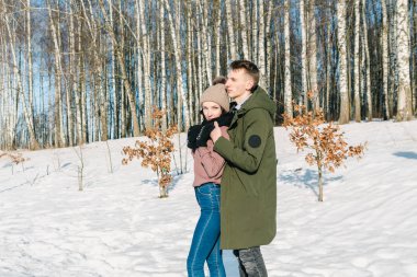 Parkta bir açık güneşli kış gününde sarılma aşık güzel genç Çift. 