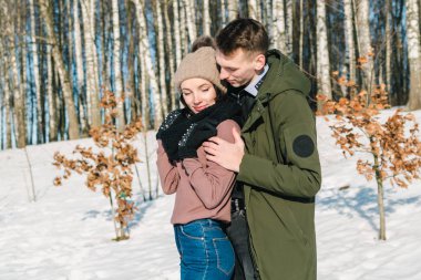 Parkta bir açık güneşli kış gününde sarılma aşık güzel genç Çift. 