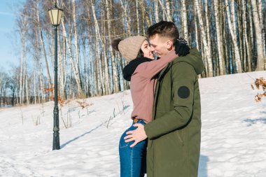 Parkta bir açık güneşli kış gününde sarılma aşık güzel genç Çift. 