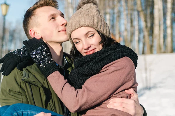 冬の晴れた日の公園で恋の美しい若いカップル 若い男が彼のガール フレンドを保持します — ストック写真