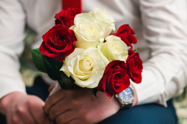 Damat elinde beyaz ve kırmızı güller güzel gelin buket, yakın