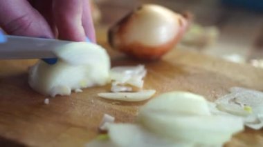 Temizlik ve ahşap bir kesme tahtası üzerinde bir bıçak ile bir soğan ampul Dilimleme süreci