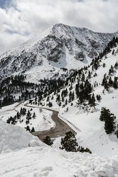 Bir kış sahne altında açık bir yol ve bazı kümülüs yukarıda ile snowed bir tepe. İspanya Vallter 2000'in Kuzey Kayak Merkezi alınan