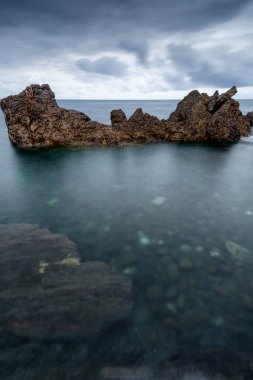 Deniz manzarası, Atlantik Okyanusu ve yarı saydam suları İspanya Bask Ülkesi'aracılığıyla görülen taş bir yatak üzerinde geniş bir kaya