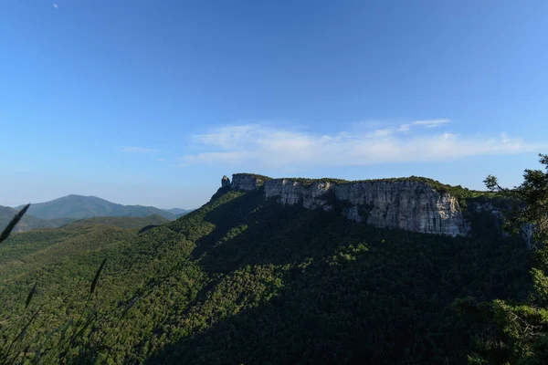 Onun yoğun yeşil orman altında ile bir dağ başında büyük bir uçurum tüm bir bakış. Mavi gökyüzü yaz ortaya koymaktadır Catalonia, İspanya
