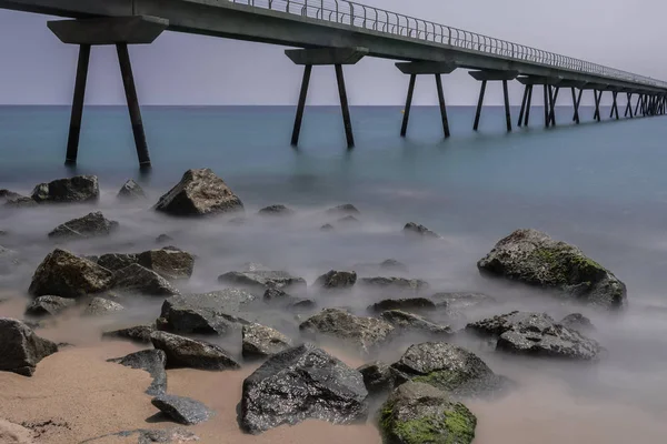 Akdeniz yaz sahne büyük köprü, onun sütundan yanı sıra bir kayalık sahil Badalona, İspanya