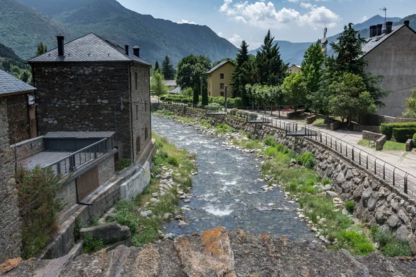 Pyrenean Köyü ile dağların Esterri d'Aneu, İspanya, önünde açık bir günde evlerde arasında geçen bir nehir rahatlatıcı bir görünümünü