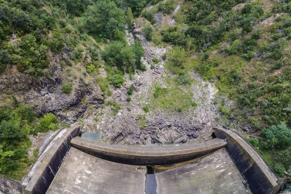 Kayaların yanında bir dam'ın arka tarafında bir beton İnşaat ve ağaçlar Amer, İspanya görünümünü yakından