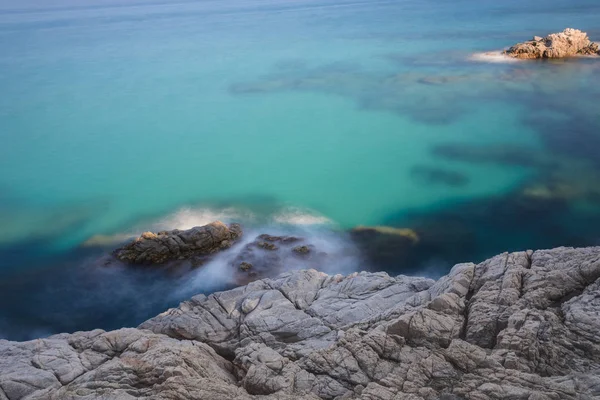 Aguas Translúcidas Muestran Algunas Piedras Bajo Mar Frente Una Costa —  Fotos de Stock