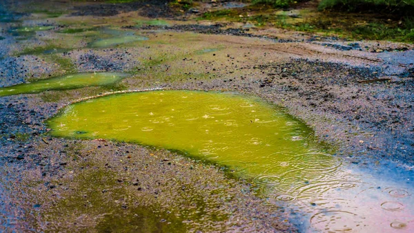 Bright yellow green dirty toxic water near oil factory illustrates global ecology problem of acid rains and water pollution